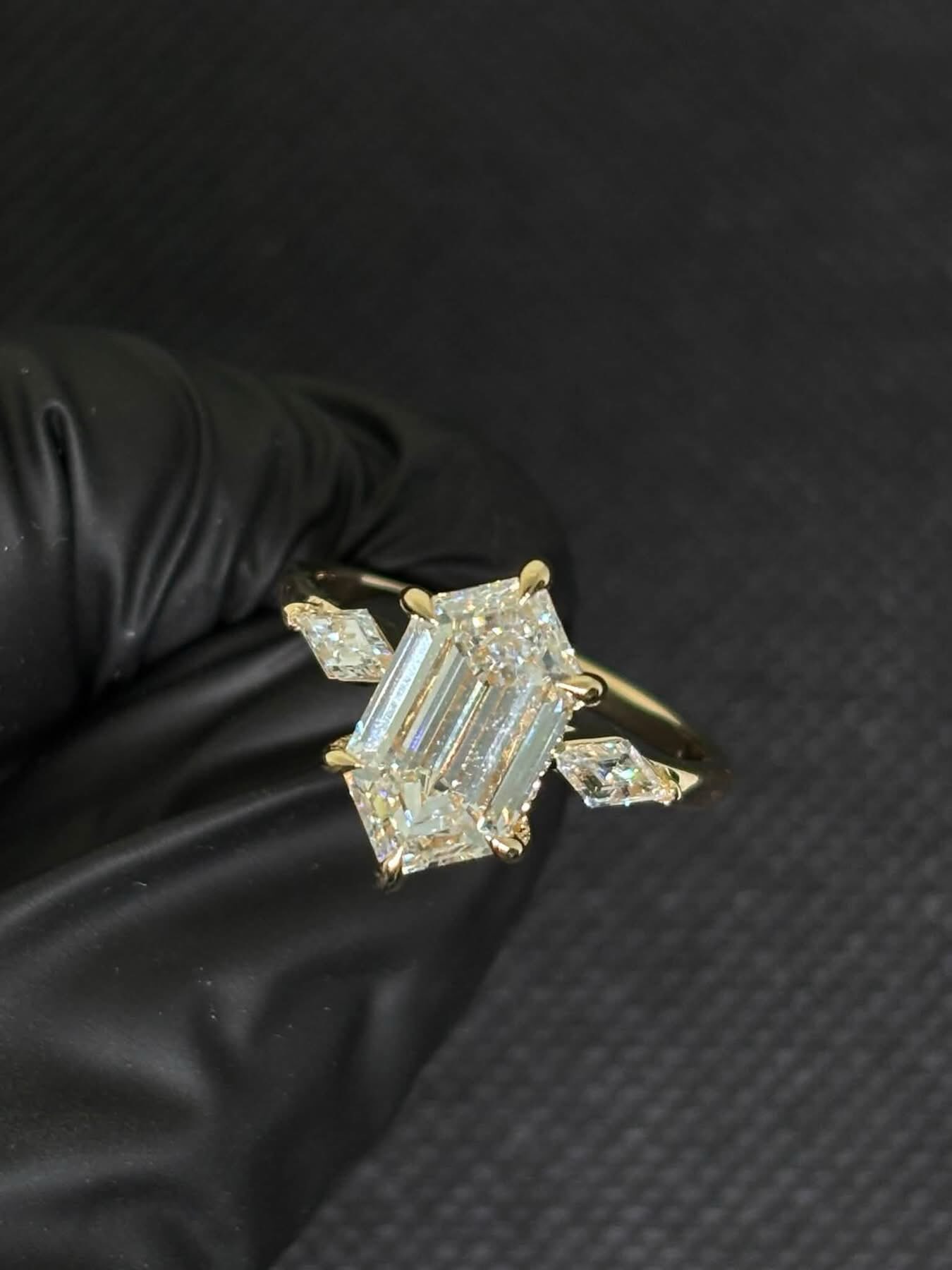 Emerald cut three-stone diamond ring